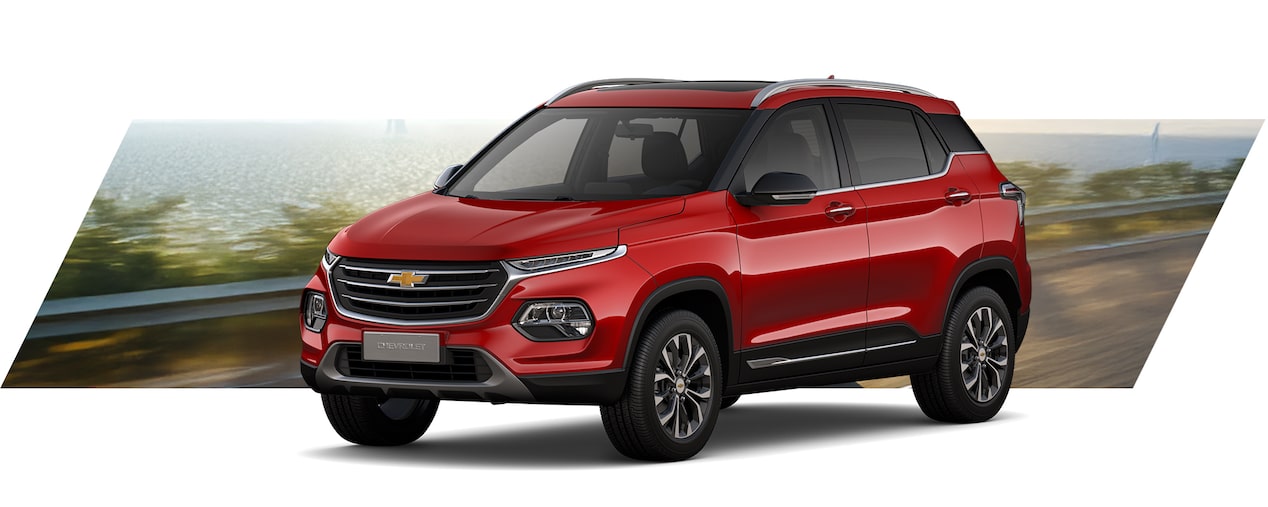 Chevrolet SUV color rojo manejando por carretera costera, diseño moderno y elegante ideal para ciudad y viajes